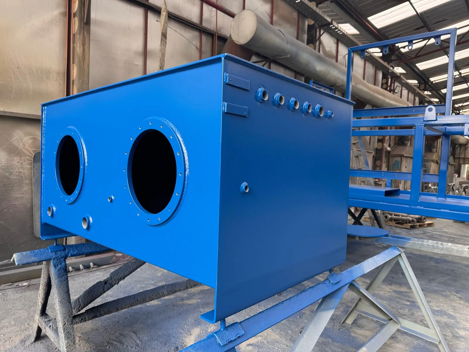 Equipo metálico con revestimiento industrial azul, fotografiado en la planta de IR